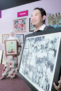 Sharul Ridzuan memegang potret hasil kolaj dan isterinya, Khairul Bariah memegang sebuah potret lama yang telah mengalami proses restorasi. 